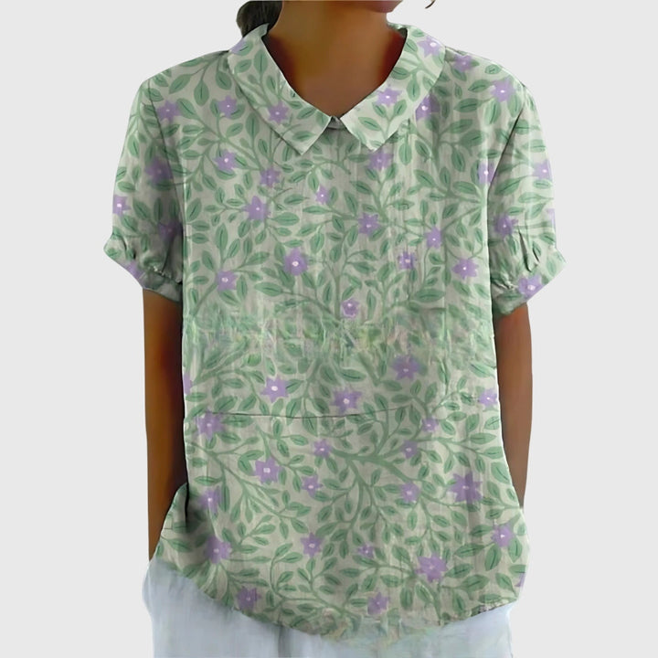Women's floral blouse on a hanger, highlighting its vibrant print and comfortable, relaxed fit.