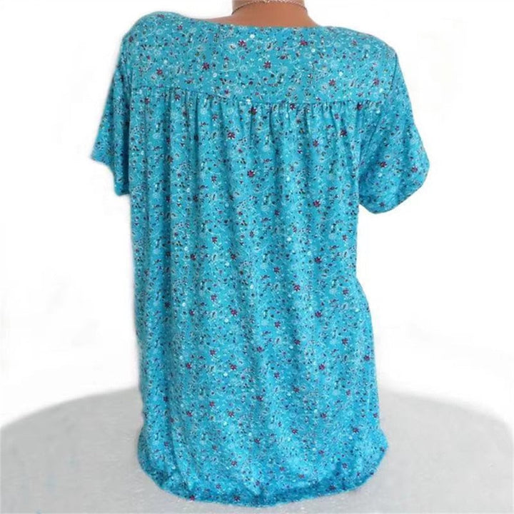Lightweight V-neck blouse for women, featuring a vibrant floral print and flutter sleeves.