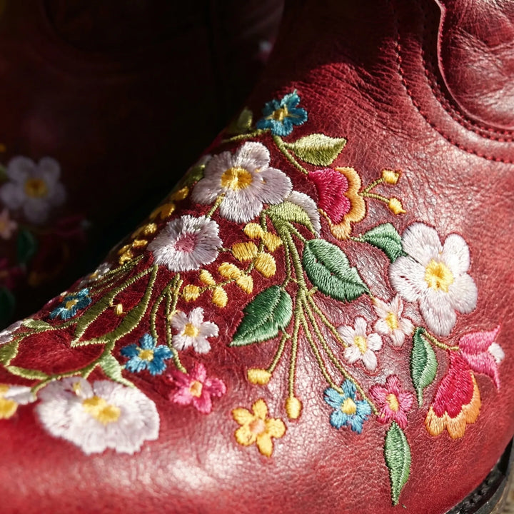Unique women's ankle boots featuring vibrant floral embroidery & western flair. Stylish & all-weather ready.