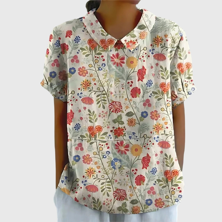 Chic women's floral short sleeve top with a distinct Peter Pan collar, offering effortless style & comfort for summer.