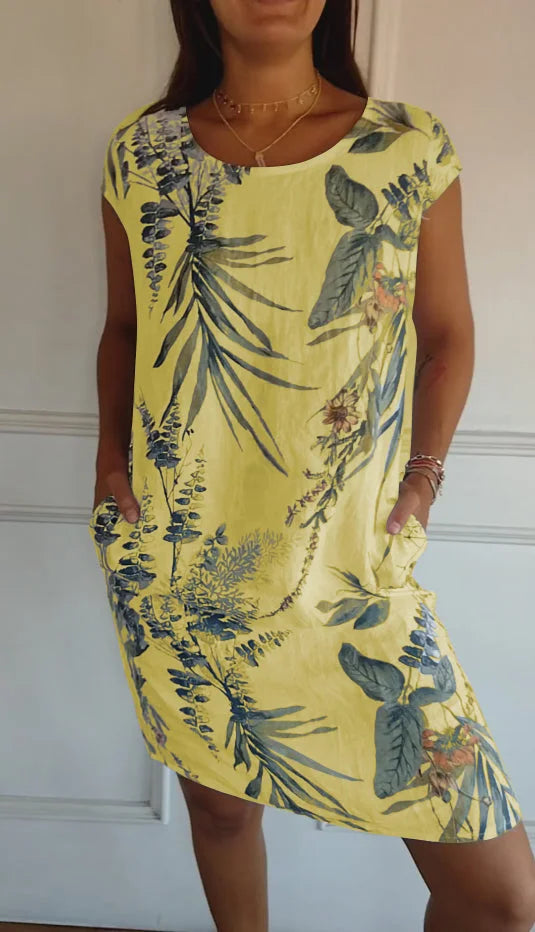 A woman models a flowing printed dress with a round neck. Comfortable, versatile, and perfect for summer.