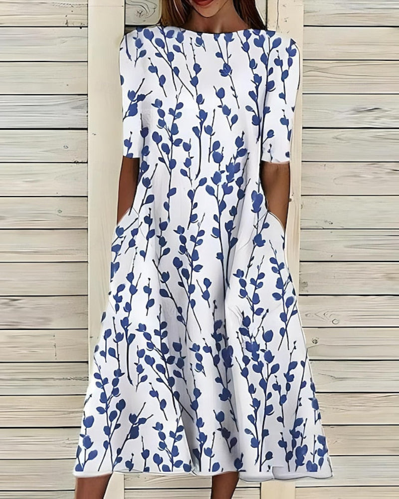 Women's flowy A-line midi dress with botanical print, pockets, crew neck, and short sleeves for summer fashion.