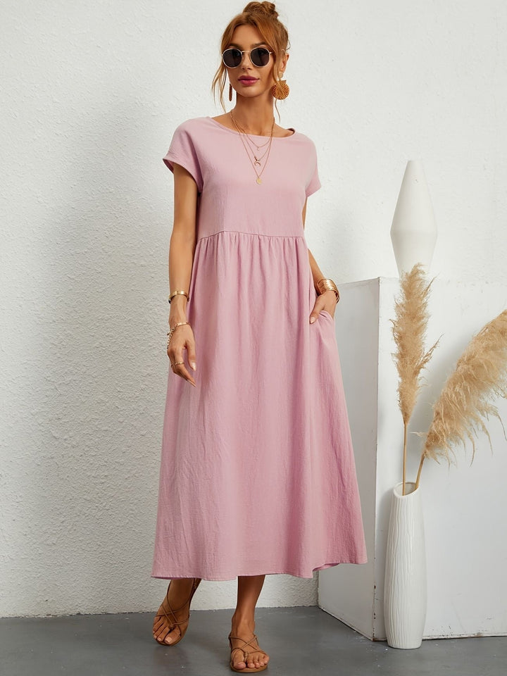 Full length view of women's flowy maxi dress, showcasing its loose fit, comfortable design & practical pockets.