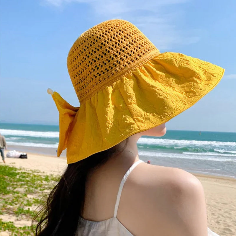 Front view of a women's foldable wide-brim sun hat, showcasing its elegant shape and bow.