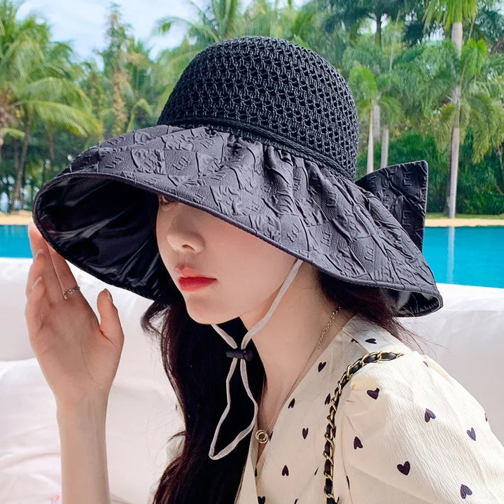 Side view of a women's foldable wide-brim sun hat, highlighting the bow detail and generous brim.