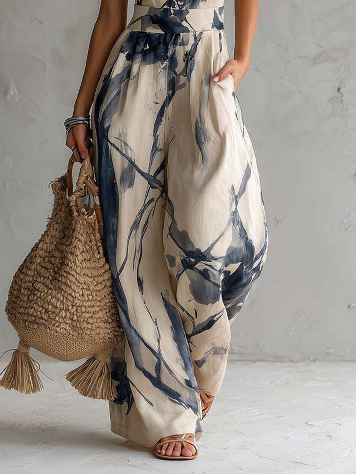 Women's elegant halter neck wide leg jumpsuit, featuring a beautiful abstract ink wash print & convenient pockets for summer.