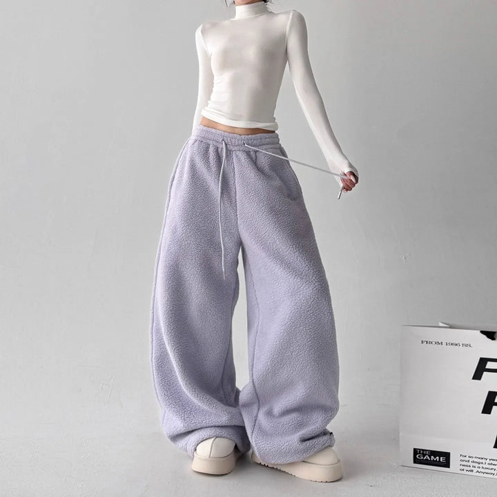 Stack of colorful women's fleece wide-leg lounge pants: navy, gray, and purple, for athleisure