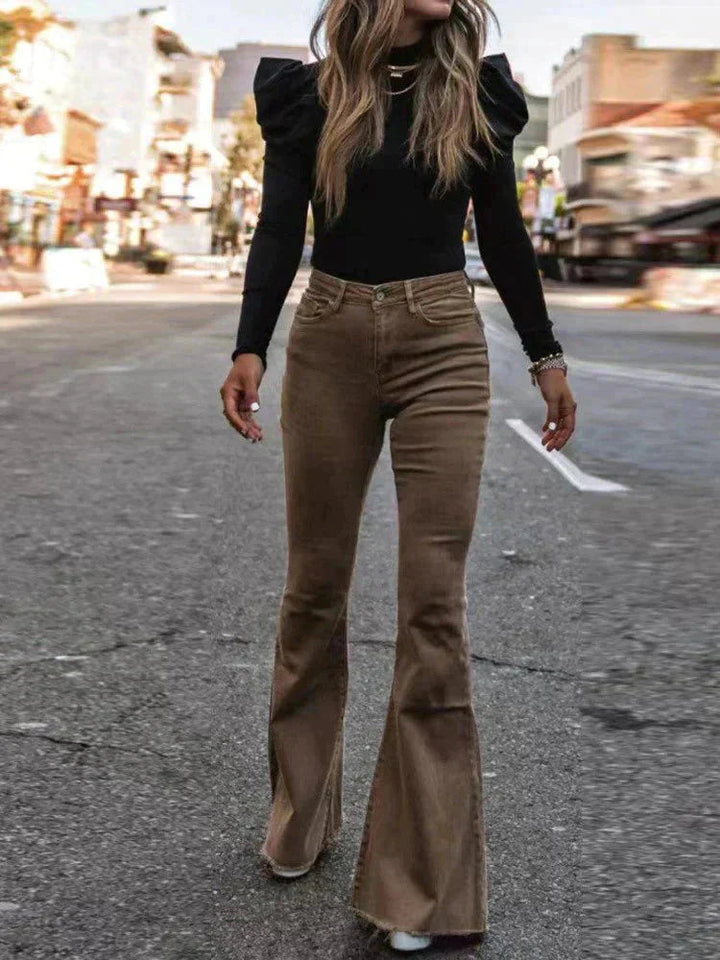 Modern women's black high-waist flare trousers, designed with pockets for convenience & style.