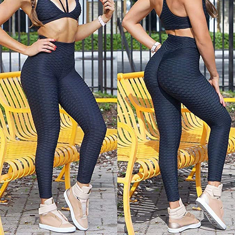 Woman stretching in high waist anti-cellulite yoga leggings, showcasing flexibility and comfort.