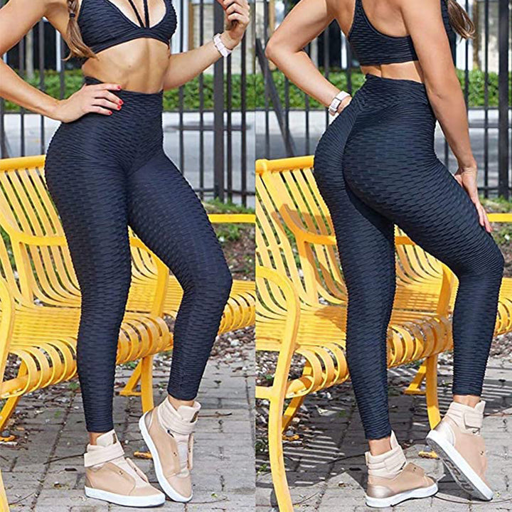 Woman stretching in high waist anti-cellulite yoga leggings, showcasing flexibility and comfort.
