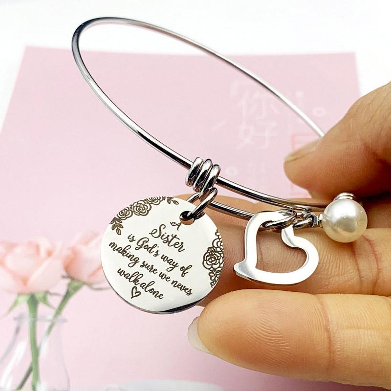 Close-up of 'Sister' engraved on a stainless steel bangle bracelet for women