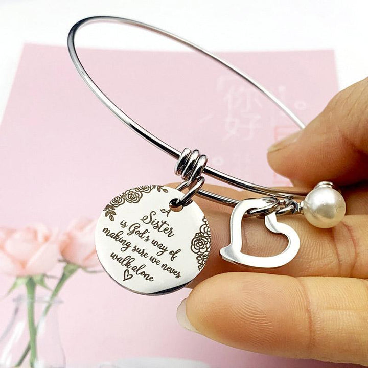 Close-up of 'Sister' engraved on a stainless steel bangle bracelet for women