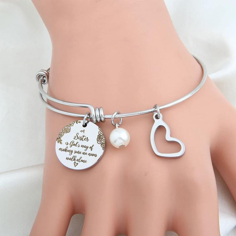 Stack of women's stainless steel bangles, one featuring 'Sister' inscription