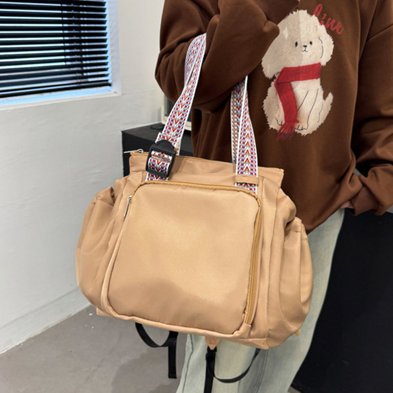 Woman carrying a black nylon convertible tote backpack over her shoulder