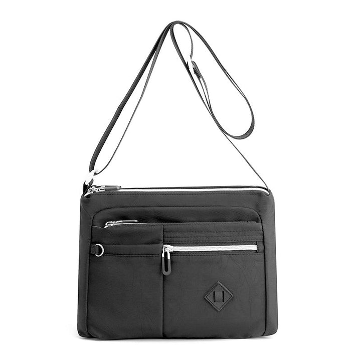 Women's multi-pocket shoulder bag in a neutral color, accentuating its practical design