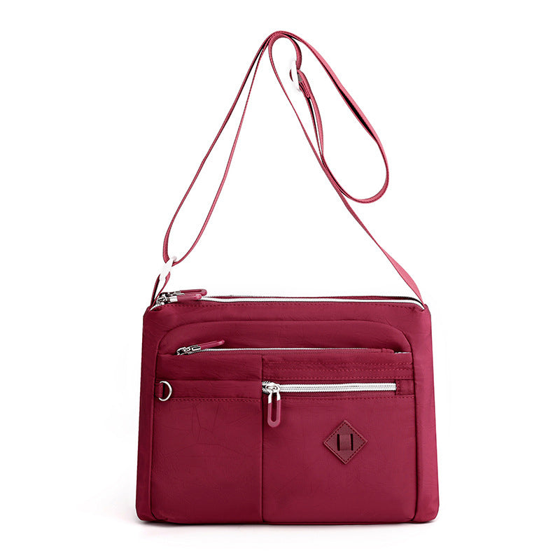 Collection of everyday essentials neatly organized within the women's travel shoulder bag