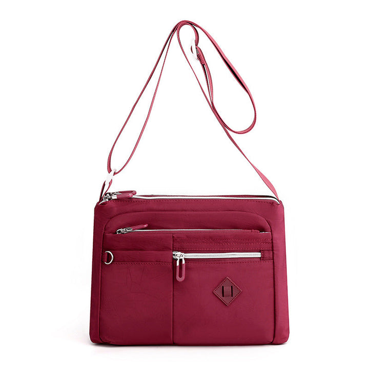 Collection of everyday essentials neatly organized within the women's travel shoulder bag
