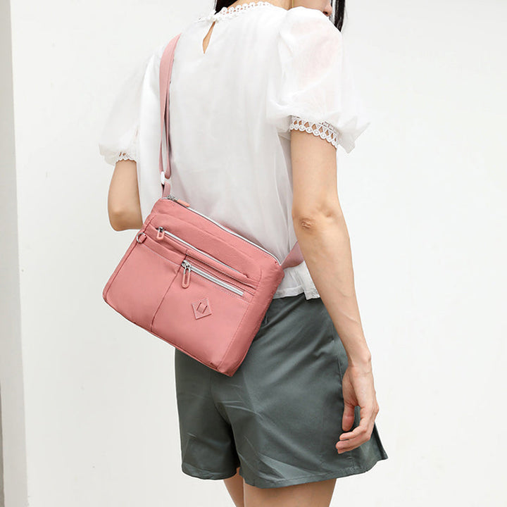 Front view of a women's multi-pocket shoulder bag, showcasing its practical design