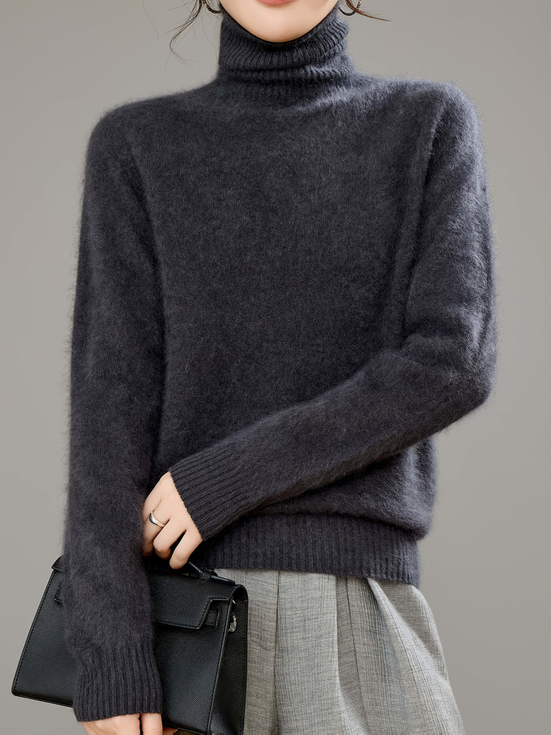 Full length view of a woman wearing a relaxed fit luxurious turtleneck sweater.
