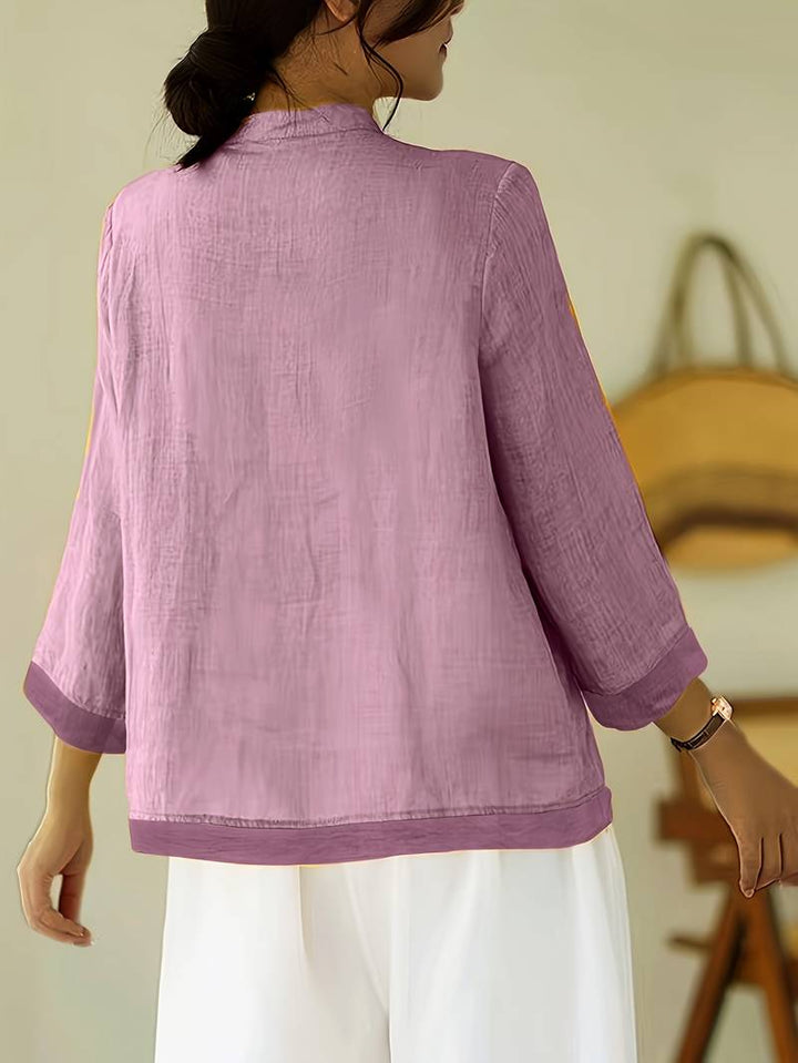 Sophisticated women's blouse, mandarin collar, unique frog button accents, tailored design.