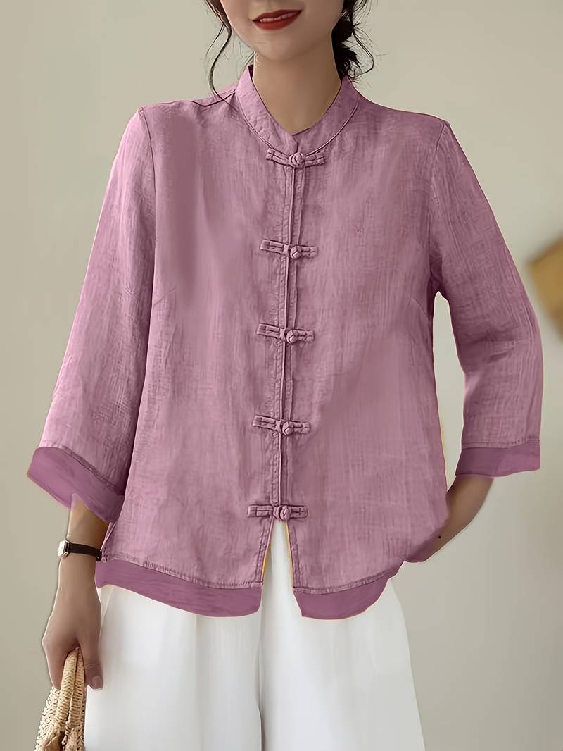 Unique women's blouse featuring a mandarin collar and decorative frog buttons, modern fit.