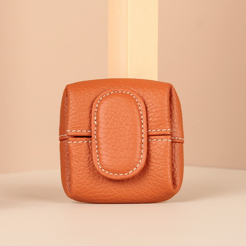 Side profile of a small blue leather coin pouch, emphasizing its slim design