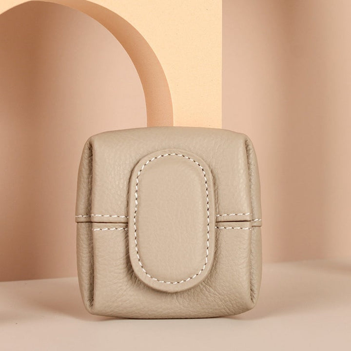 Open view of a mini black leather coin purse with a soft lining, quality interior