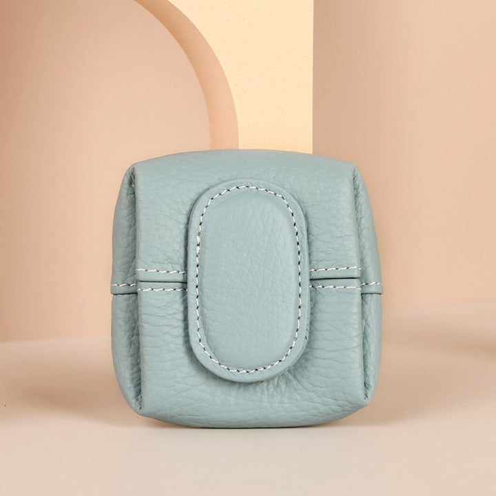 Women's mini red leather coin purse against a contrasting background, vibrant color