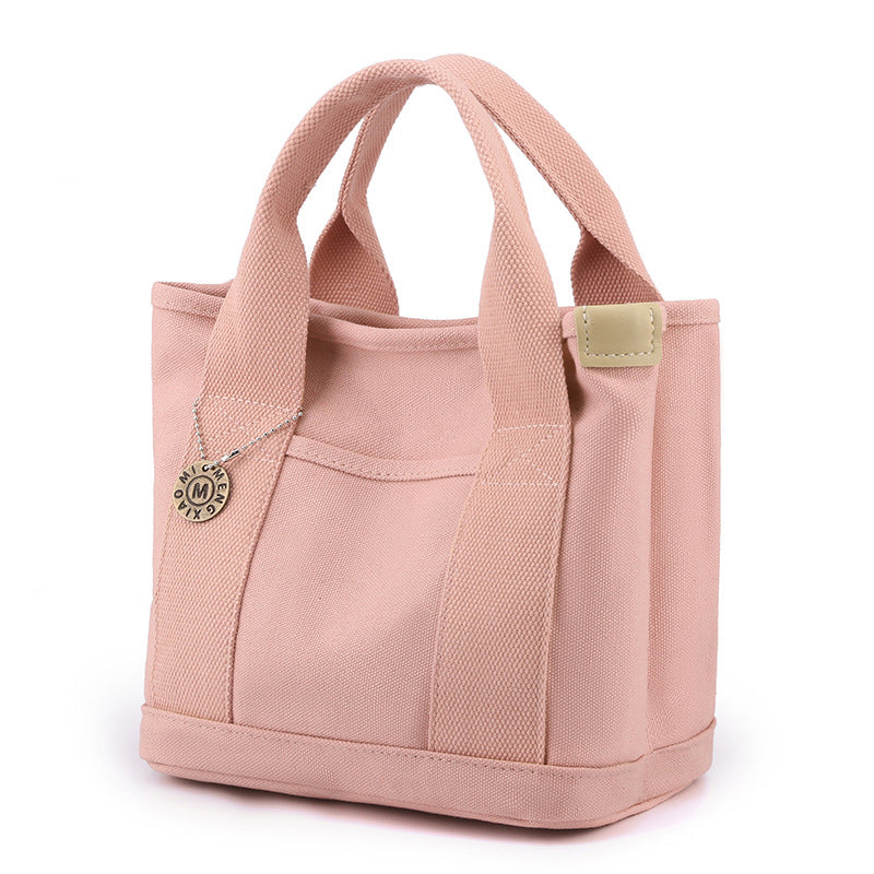 Textured shot of the premium canvas fabric used in this women's multi-pocket handbag
