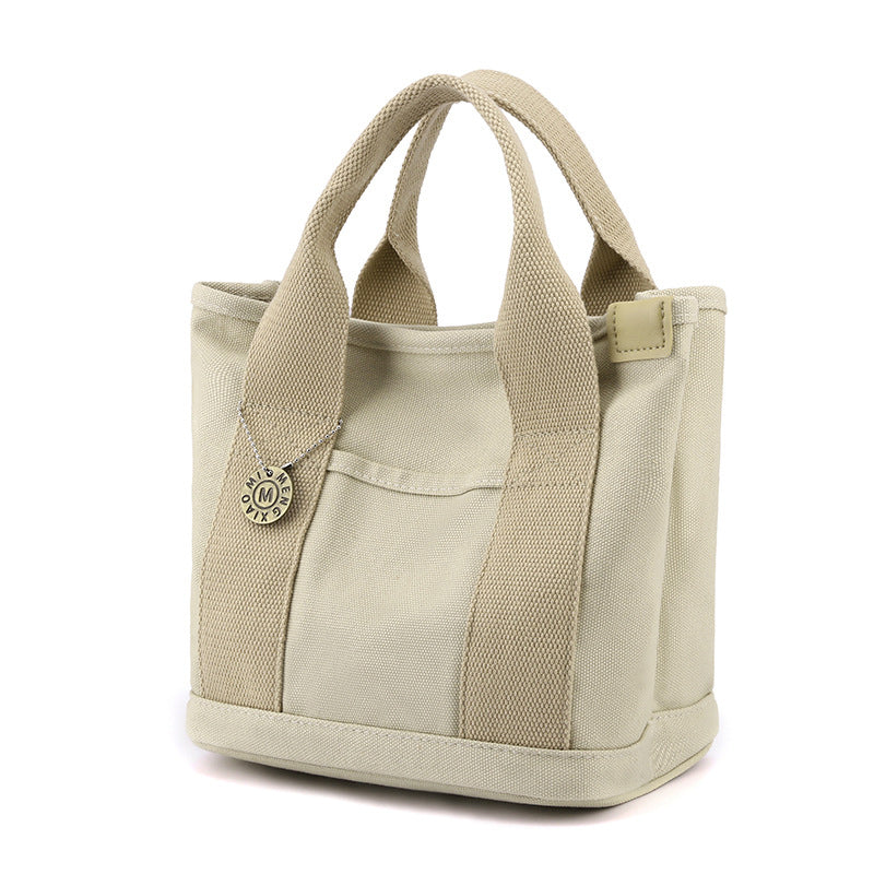 Women's daily canvas shoulder bag featuring multiple zippered and open pockets