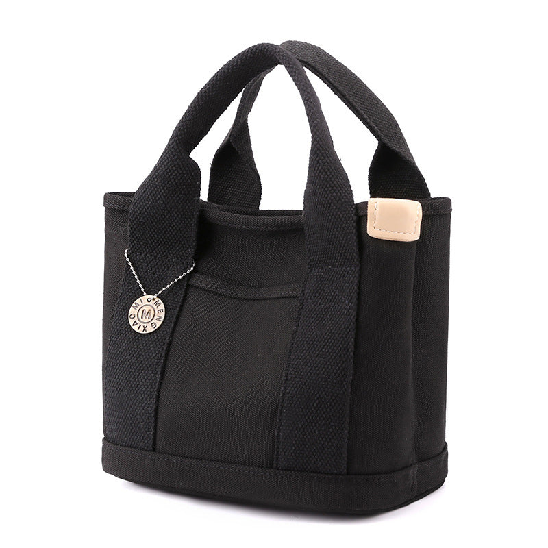 Detailed image of the hardware and buckles on a women's multi-pocket canvas handbag