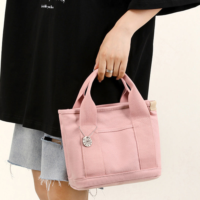 Close-up of the durable canvas material and detailed stitching of a multi-pocket handbag