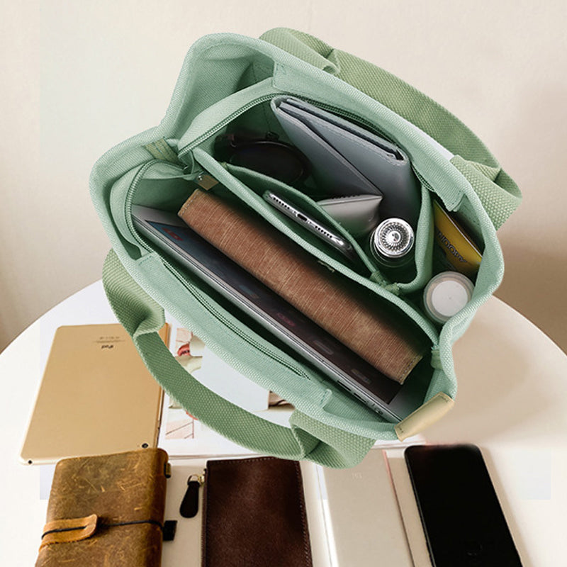 Women's versatile canvas handbag with adjustable strap and numerous storage pockets