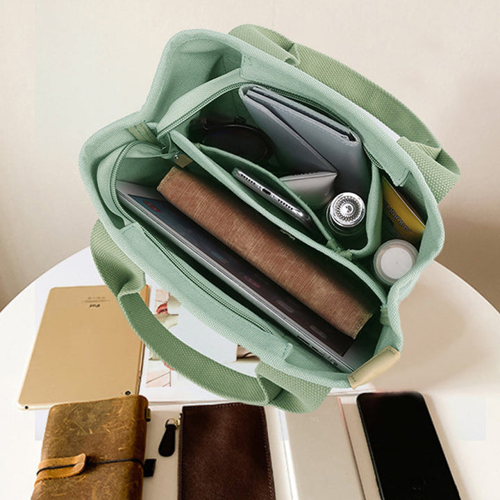 Women's versatile canvas handbag with adjustable strap and numerous storage pockets