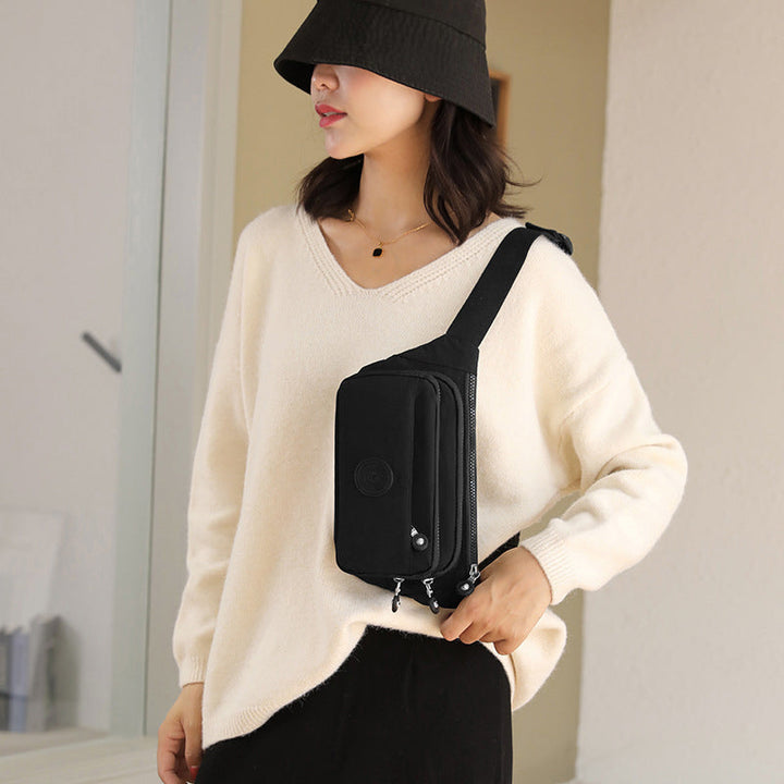 Front view of black women's multi-pocket nylon crossbody bag, showcasing zipper pockets