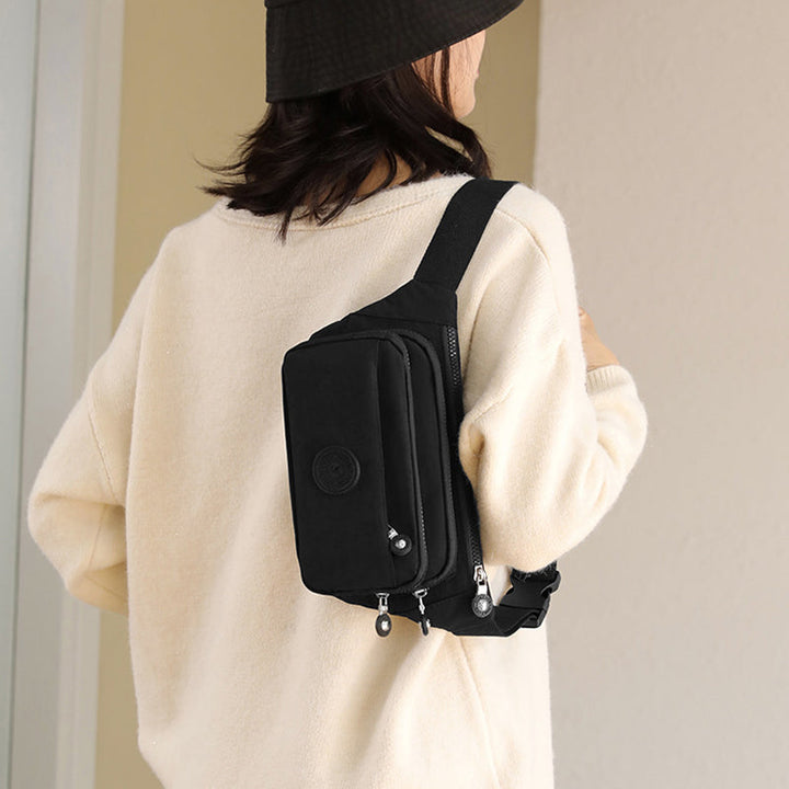 Side profile of a lightweight women's nylon crossbody bag, revealing its slim design