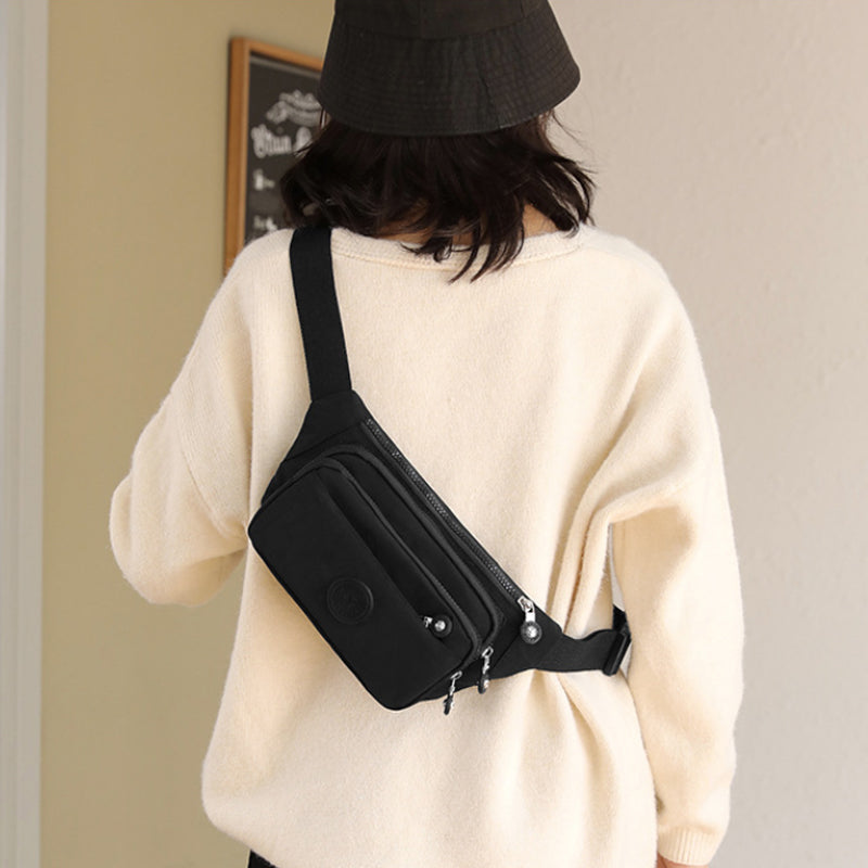 Rear view of women's multi-pocket nylon crossbody bag with an additional zippered pocket