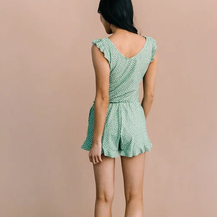Women's swim romper with a built-in bra, shown next to a beach bag, ready for a summer outing.