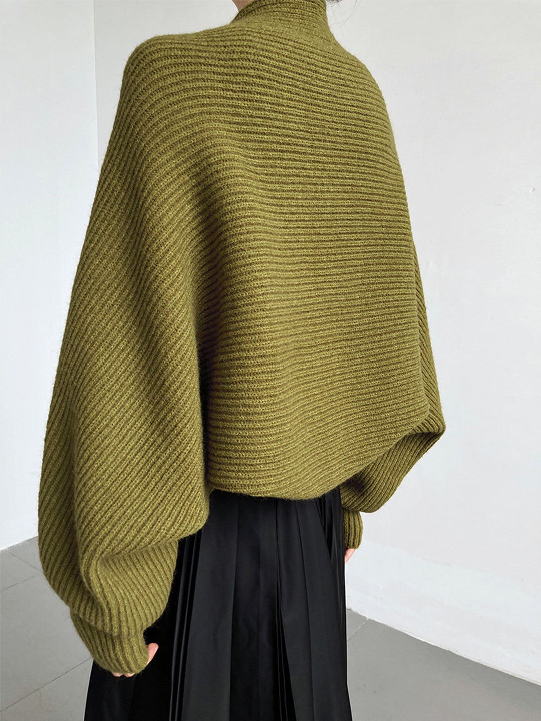 Elegant women's open-front long sleeve shrug sweater worn over a dress. Chic and versatile layering piece.
