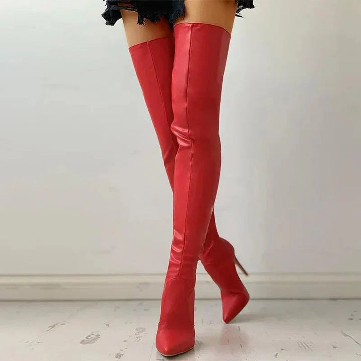 Striking red over-the-knee stiletto boots with a sharp pointed toe & slim silhouette, ideal for fashion statements.