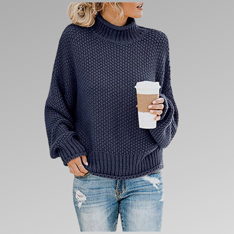 Close-up of the cozy chunky knit texture on a women's oversized turtleneck sweater, warm and soft.