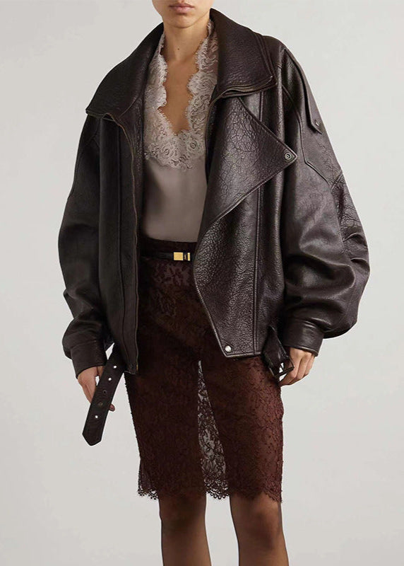 Fashionable women's brown faux leather bomber jacket, oversized fit with statement belt detail.