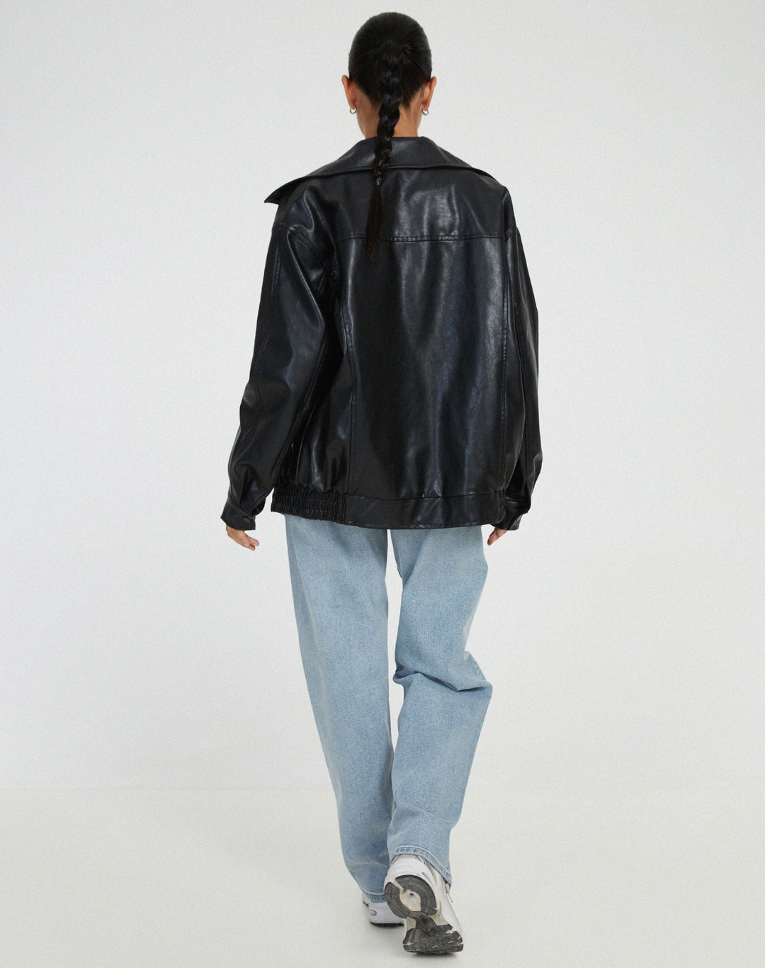 Close-up of the ribbed cuffs and hem on a women's faux leather bomber jacket, a fall fashion essential.