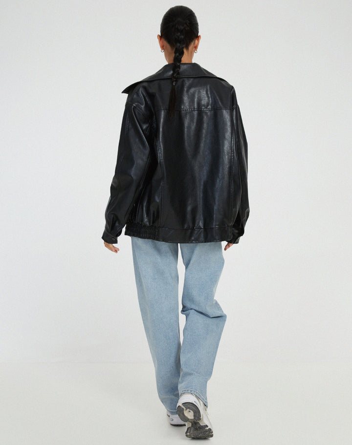 Close-up of the ribbed cuffs and hem on a women's faux leather bomber jacket, a fall fashion essential.
