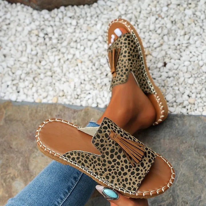 Vibrant patterned open toe women's slide sandals with playful tassels. Slip-on comfort for summer days.