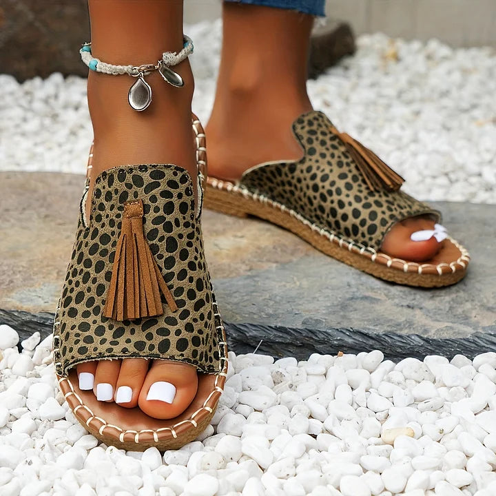 Elegant women's tassel slide sandals with a vibrant pattern and open toe design. Flat sole for comfort.