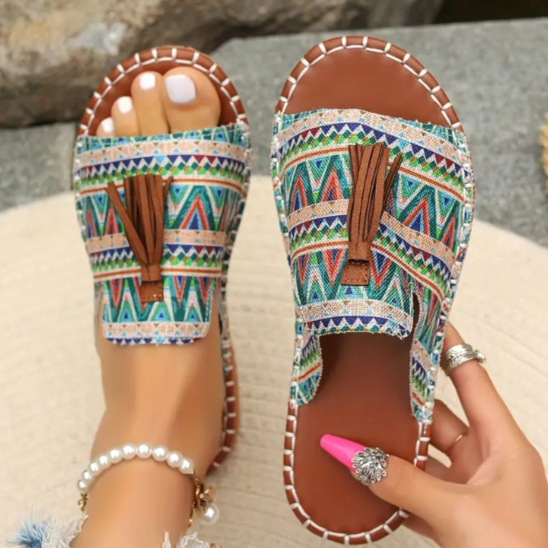 Flat sole patterned open toe slide sandals for women, featuring tassels. Comfortable and perfect for summer beachwear.