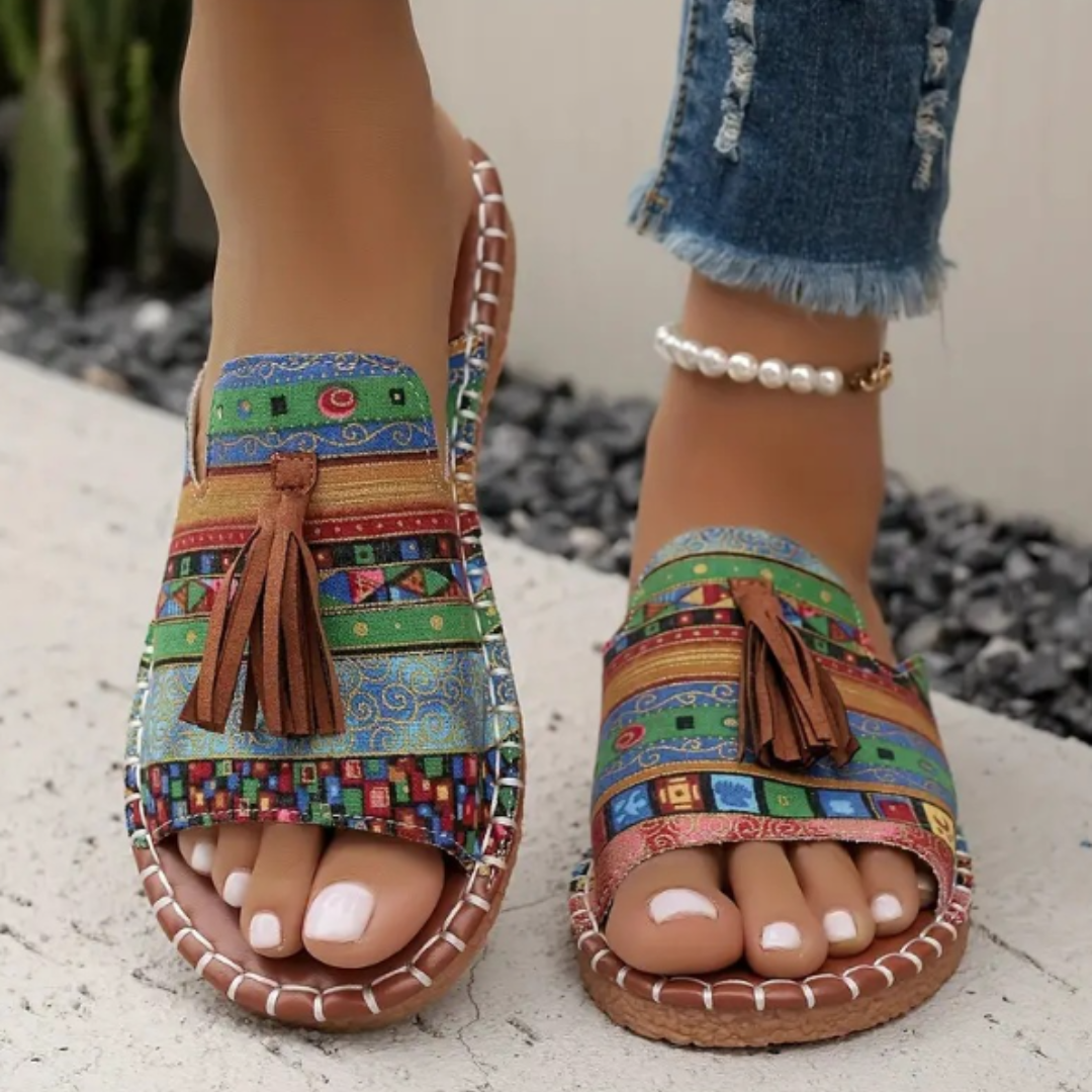 Women's patterned open toe slip-on sandals with decorative tassels. Stylish and comfortable casual summer slides.
