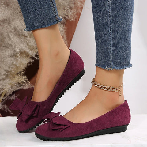 Comfortable women's slip-on ballet flats in a neutral tone with a front bow detail, ideal spring footwear.