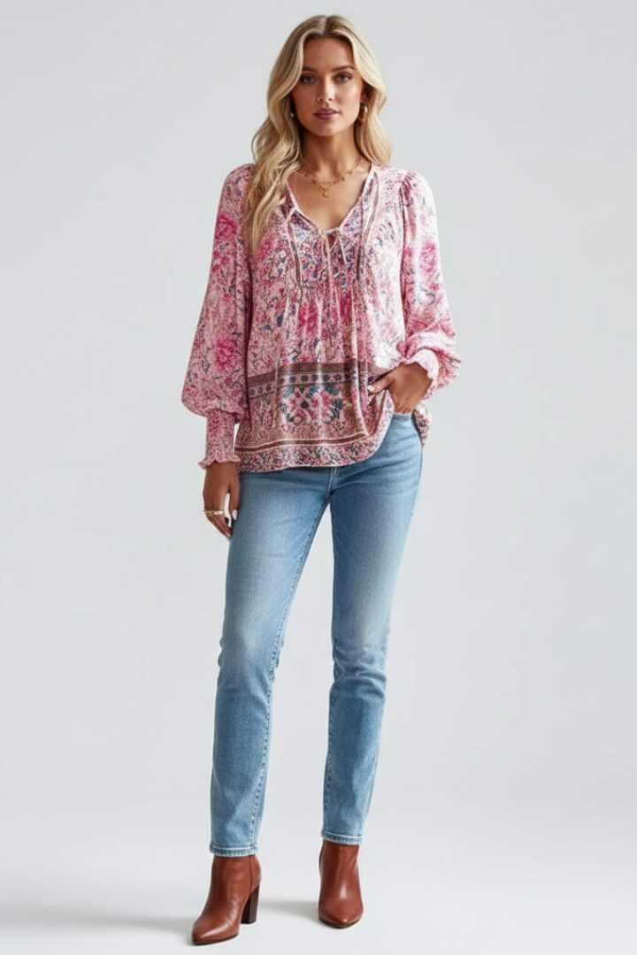 Close-up of a women's floral blouse featuring pink, green & orange blossoms. Soft fabric, ideal for feminine style.